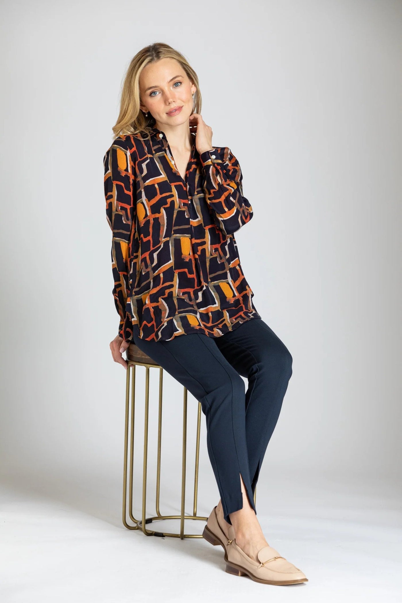 Fall Abstract Print Three Button Pullover Tunic Seated in Chair.