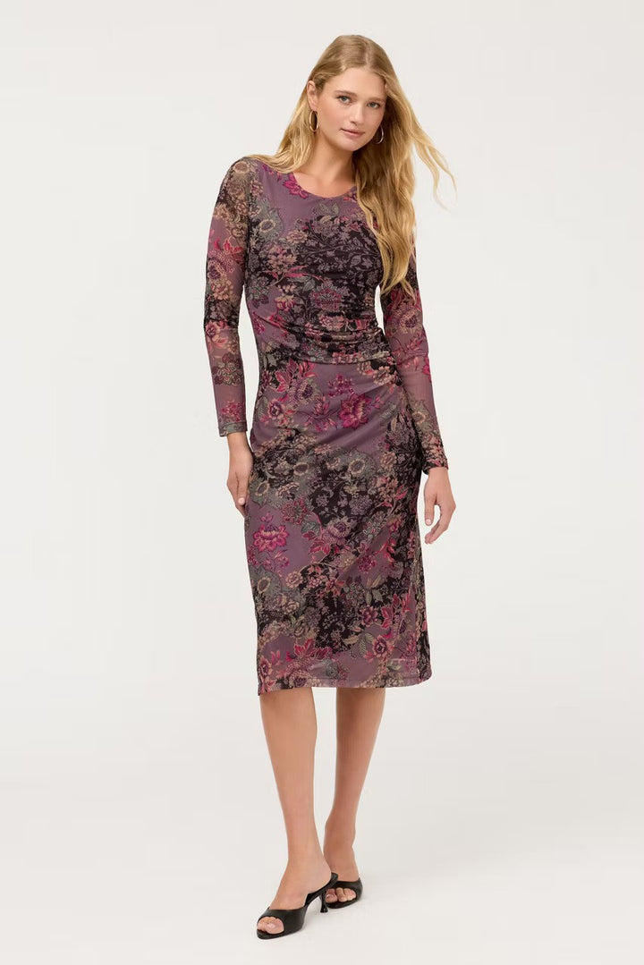 A woman modeling The Johnny Was Long Sleeve Ruched Front Mesh Midi Dress with a floral jacquard pattern in purple, pink, and black, paired with black heeled sandals, against a plain white studio background.