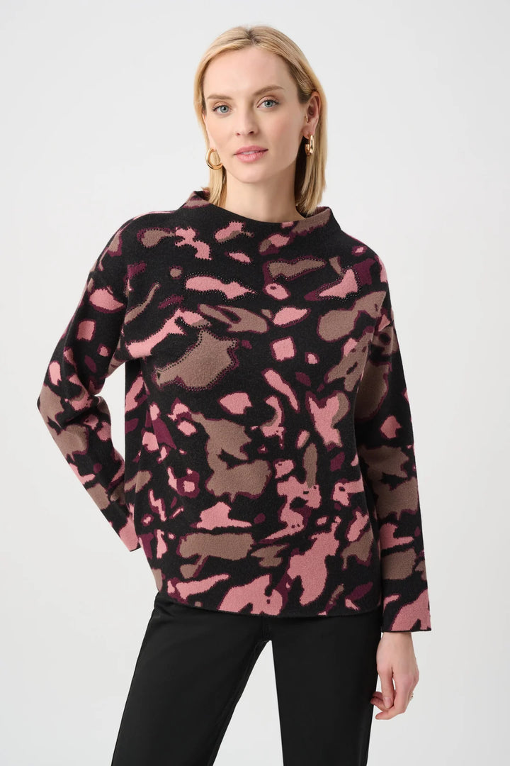 A woman modeling the Joseph Ribkoff Abstract Print Sweater Style 263930, paired with black pants, against a light gray studio background.