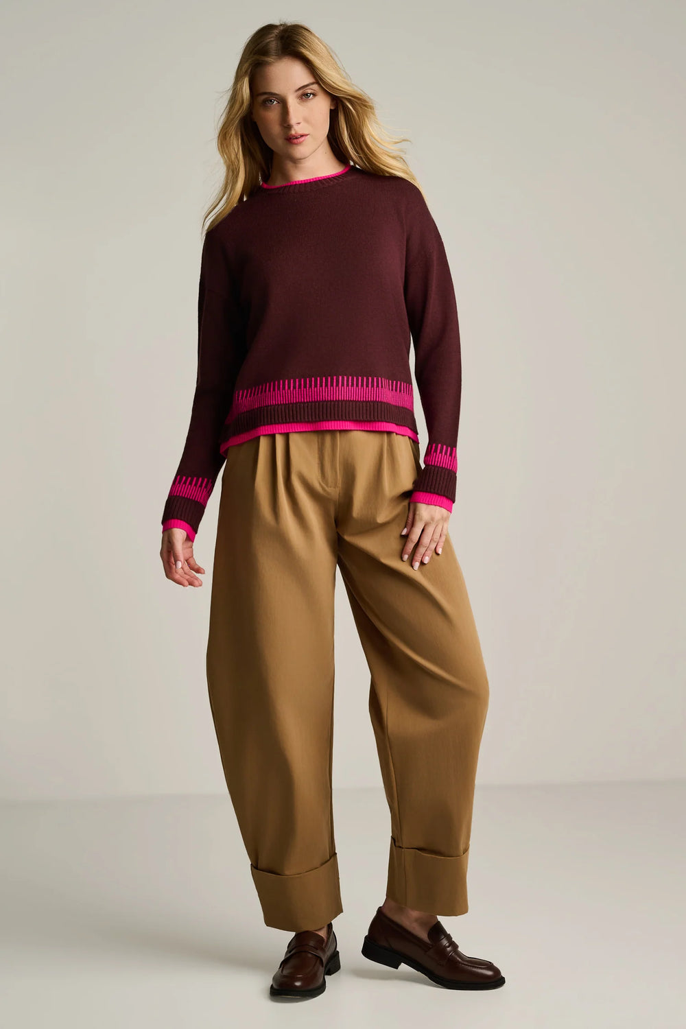 Full-length view of the Lisa Todd Point Taken sweater styled with wide-leg tan trousers and leather loafers.